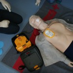 Schülerinnen üben den Umgang mit dem Defibrilator